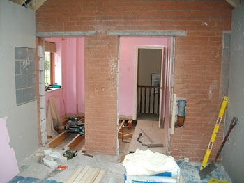 View from the garage extension into existing small bedroom to be converted into en-suite shower room and door recess